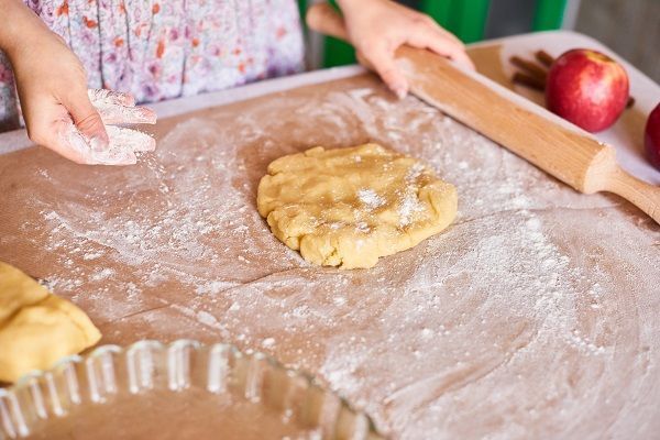 Mujer amasando la masa para el pastel de manzana