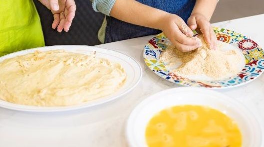 Haciendo croquetas a partir de la masa y pasándolas por pan rallado