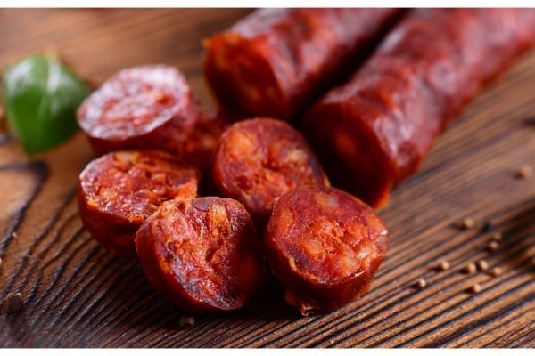 Chorizo cortado en rodajas en tabla de madera