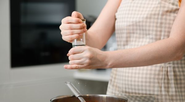Mujer añadiendo especias a la olla