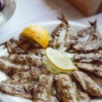 Sardinas al horno presentadas en plato con limón