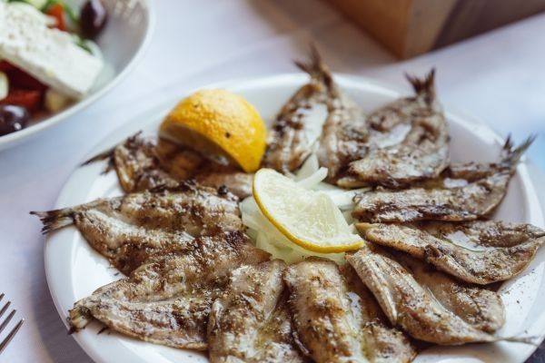 Sardinas al horno presentadas en plato con limón