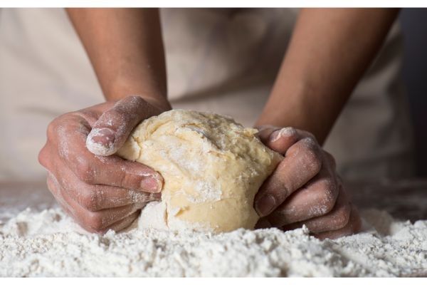 Amasar la masa de la pizza en una mesa enharinada