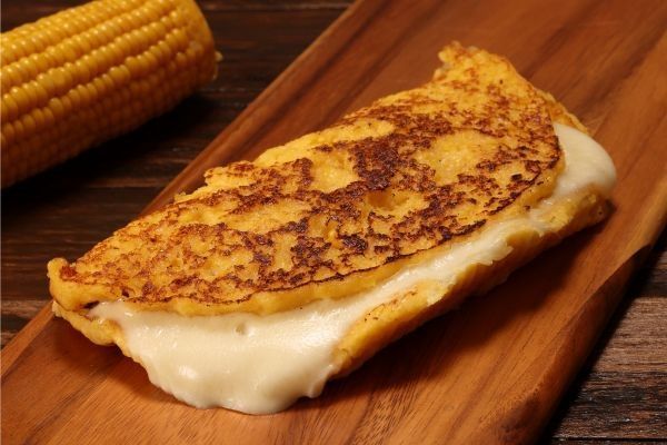 Cachapa venezolana rellana de queso en tabla de madera
