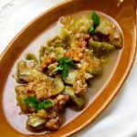 Alcachofas con jamón presentadas en plato de barro