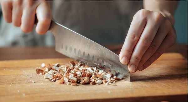 Almendras picadas con cuchillo en tabla de madera