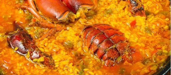 Arroz con bogavante cocinándose a fuego lento en la olla