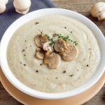 Crema de champiñones presentada en plato blanco