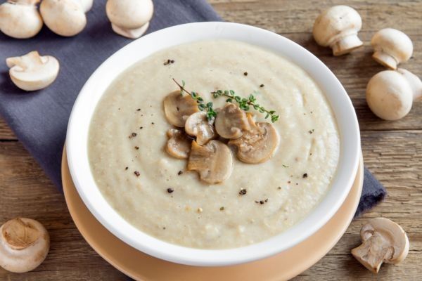 Crema de champiñones presentada en plato blanco