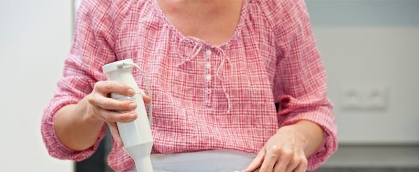 Mujer con una licuadora de inmersión en la mano
