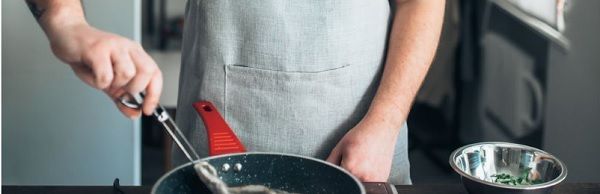 Chef friendo lubina en la sartén