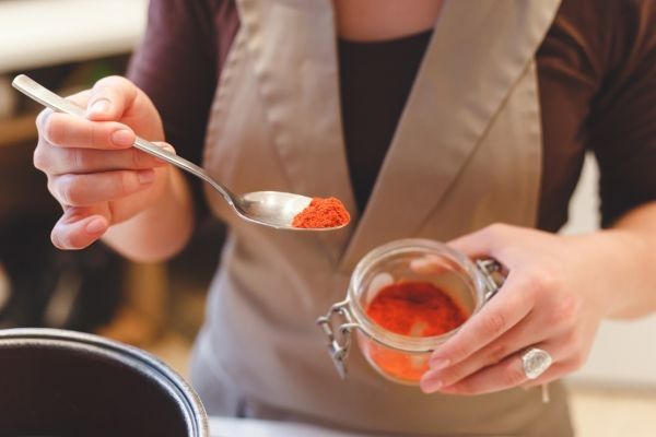 Mujer añadiendo pimentón en una cuchara