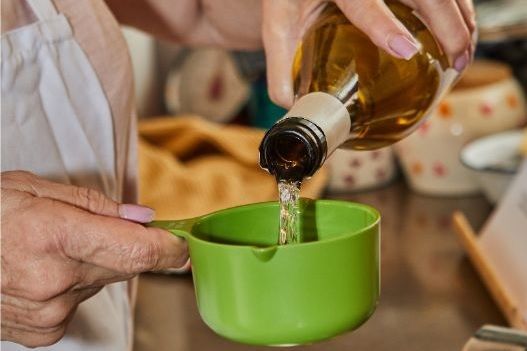 Chef echando vino blanco en un vaso medidor