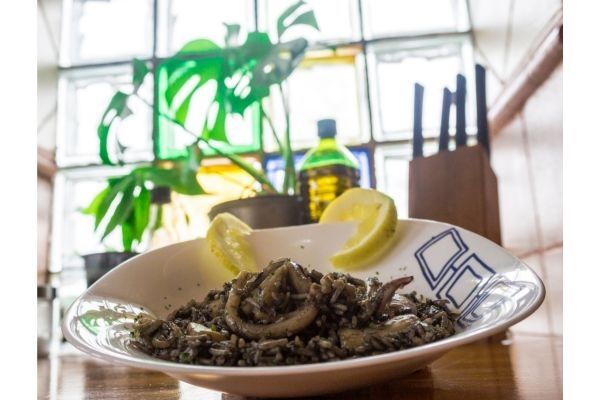Arroz negro presentado en planto blanco con un limón decorado