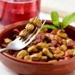 Habas con jamón en cazuela de barro con tenedor