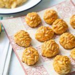 Panellets de piñones presentados en plato cuadrado junto sus ingredientes