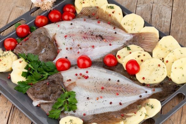 Rodaballo crudo en bandeja de horno con patatas y verduras