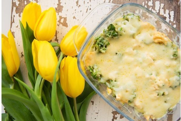 Romanescu presentado en fuente de cristal junto a tulipanes amarillos