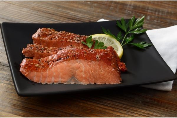 Salmón ahumado casero presentado en plato cuadrado negro