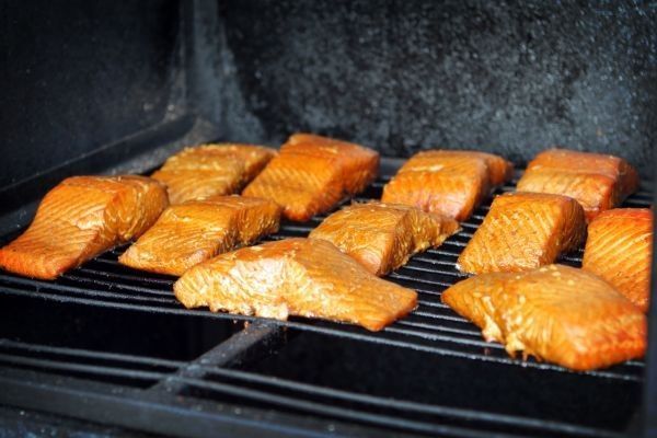 Salmón ahumándose lentamente en el ahumador