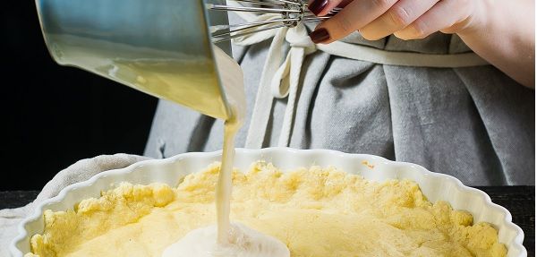 Vertiendo una capa de bechamel en la fuente de horno