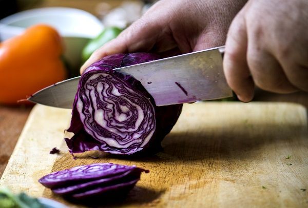 Chef cortando con cuchillo una col lombarda
