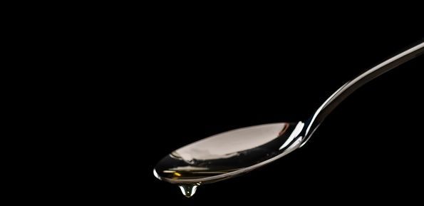 Cuchara con aceite cayendo
