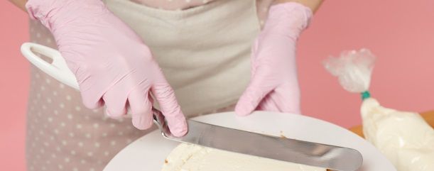 Pastelero extendiendo nata sobre el bizcocho