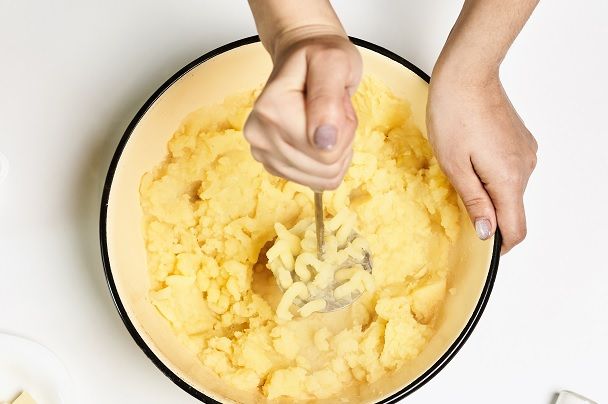 Chef triturando patatas en un bol