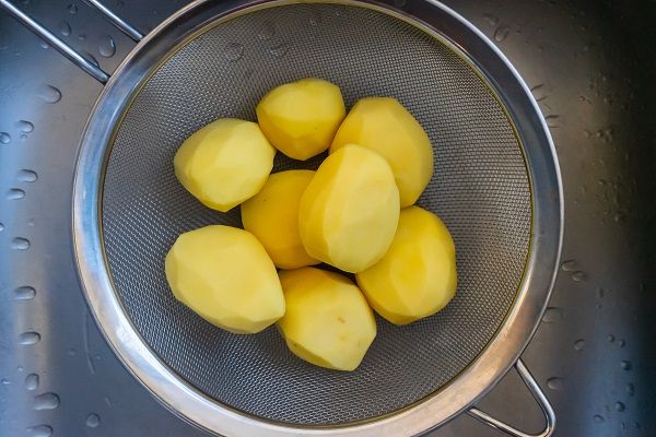 Patatas enteras peladas sobre un escurridor