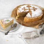 Tarta de Santiago con una porción cortada presentada en plato blanco y cuchara