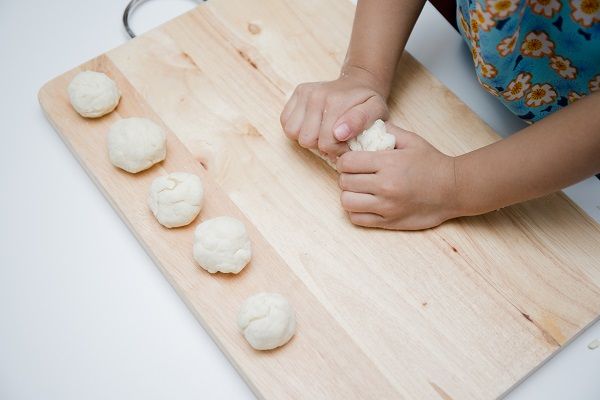 Chef haciendo bolitas de masa con las manos para hacer chipá