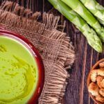 Crema de espárragos verdes presentada en cuenco de barro junto a unos espárragos trigueros y unos crutones