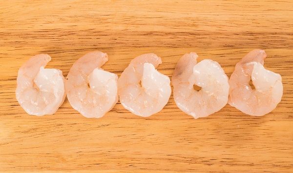 Gambas peladas sobre tabla de madera