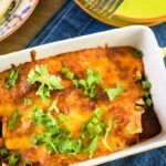 Enchilada de pollo recién hecha presentada en fuente blanca para horno