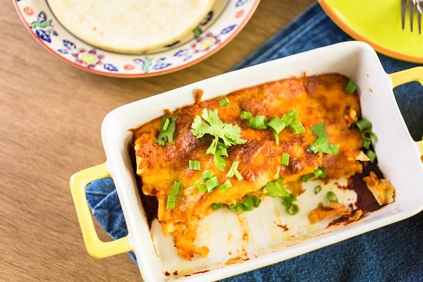 Enchilada de pollo presentada en fuente blanca recién hecha