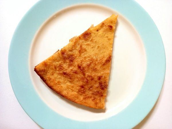 Fainá cortada en triángulo sobre plato azul y blanco