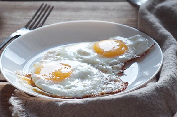 Huevo frito con puntilla presentado en plato blanco