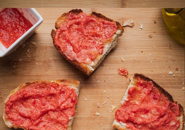 Tomate extendido en las rebanadas de pan