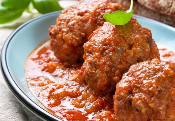 Albóndigas con tomate de la abuela presentadas en plato de tapa y con hojita de menta
