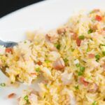 Arroz chaufa presentado en plato blanco con tenedor