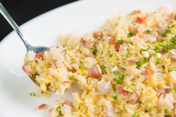 Arroz chaufa presentado en plato blanco con tenedor