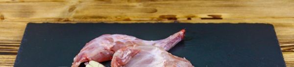 Carne de conejo cruda sobre tabla negra