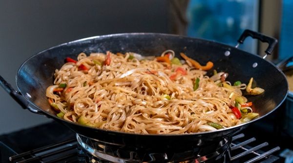 Sartén con noodles y verduras al fuego