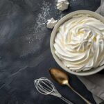 Crema Chantilly en bol blanco con utensilios alrededor