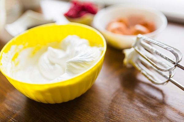 Crema chantilly en bol amarillo recién hecha