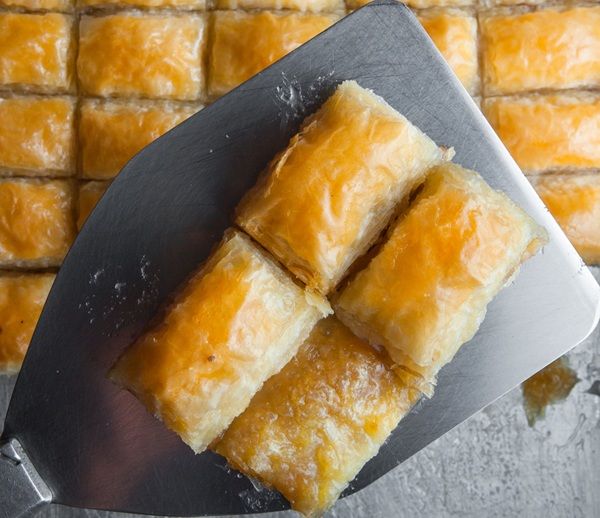 Dulces árabes sirviéndose con una espumadera de metal