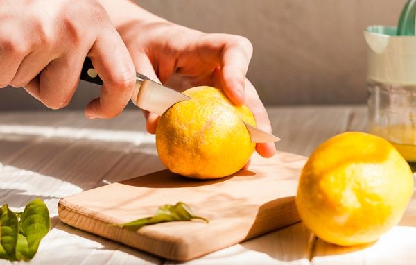 Chef cortando limones sobre tabla de madera