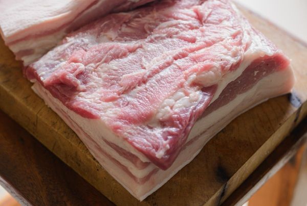 Panceta de cerdo cruda sobre tabla de madera