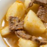 Papas guisadas con carne presentadas en plato blanco